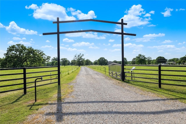 view of road featuring a rural view, driveway, and a gated entry