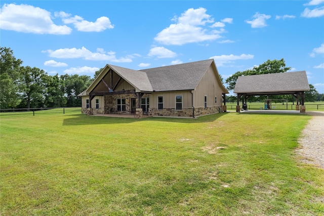 rear view of house featuring a gazebo, a lawn, stone siding, and a carport