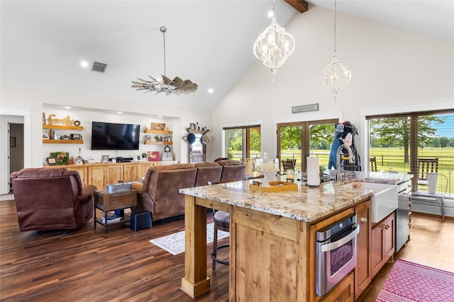 kitchen featuring visible vents, open floor plan, high vaulted ceiling, a chandelier, and a sink