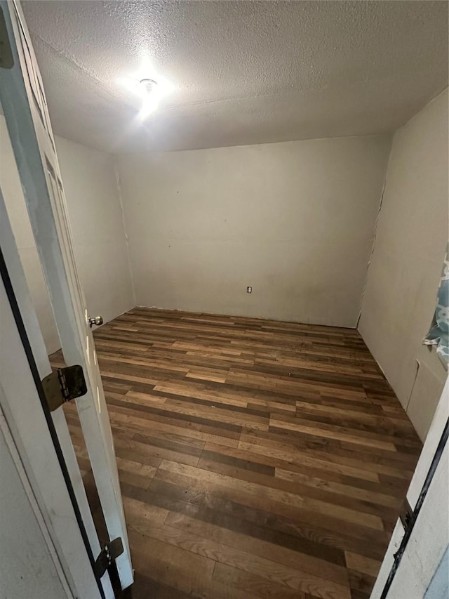 unfurnished room with a textured ceiling and hardwood / wood-style flooring