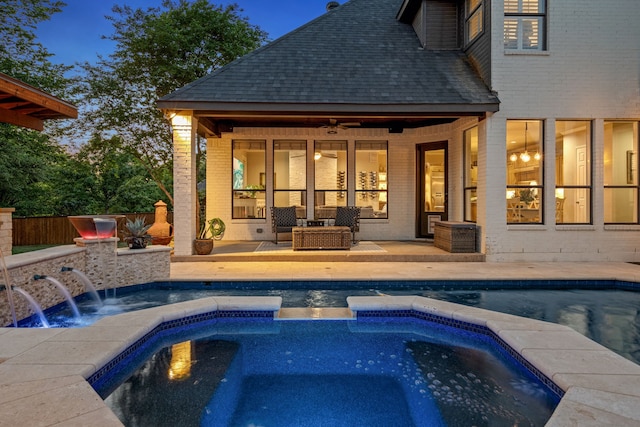 view of pool featuring ceiling fan, fence, a pool with connected hot tub, and a patio area