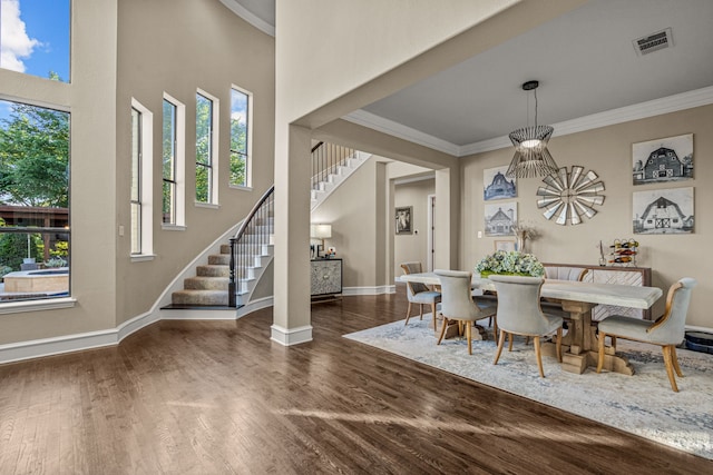 dining room featuring a healthy amount of sunlight, crown molding, stairs, and visible vents