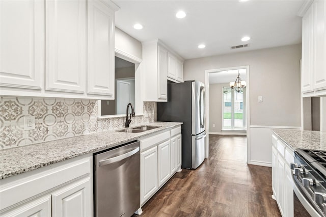 kitchen with stainless steel appliances, white cabinetry, and a sink