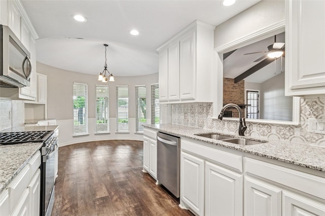 kitchen with white cabinetry, appliances with stainless steel finishes, decorative backsplash, and a sink
