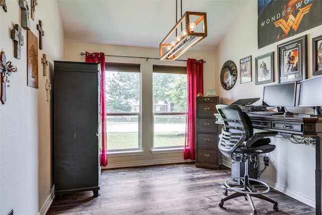 office space with baseboards, vaulted ceiling, and wood finished floors