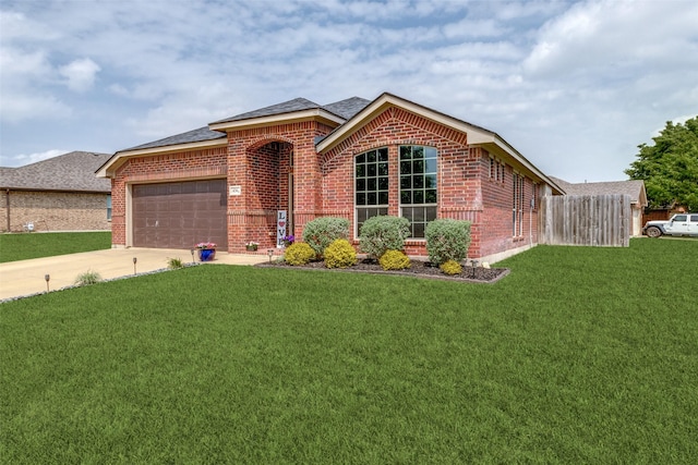 ranch-style home with a front lawn, brick siding, a shingled roof, an attached garage, and driveway