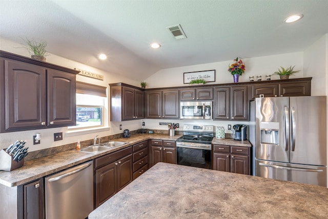 kitchen with dark brown cabinetry, appliances with stainless steel finishes, a sink, lofted ceiling, and visible vents