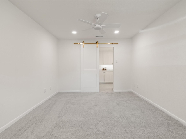 unfurnished room with light colored carpet, recessed lighting, and baseboards
