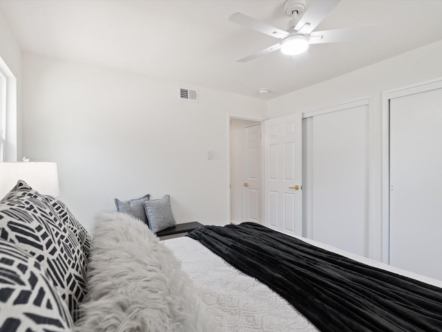 bedroom featuring a ceiling fan, two closets, and visible vents
