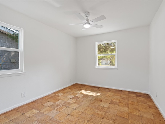 spare room featuring baseboards and a ceiling fan