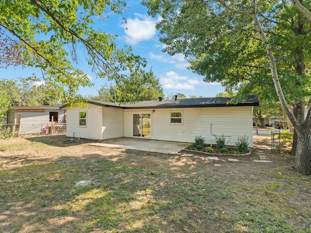 rear view of property with fence and a patio