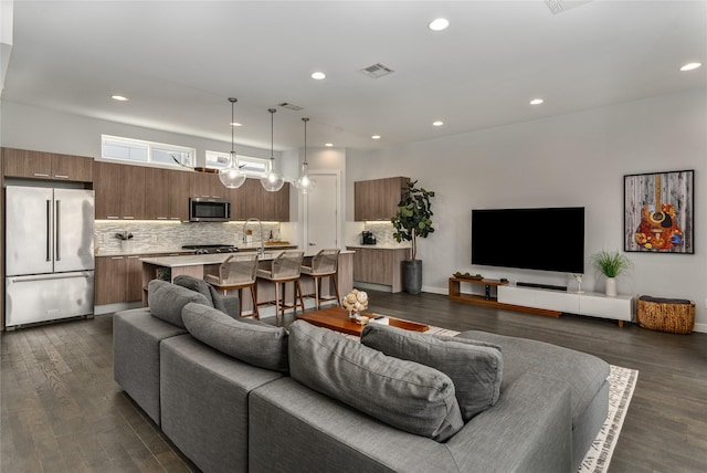 living room with visible vents, recessed lighting, dark wood-style flooring, and baseboards
