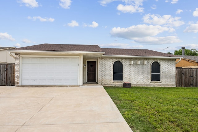 single story home with fence, an attached garage, a front lawn, brick siding, and driveway