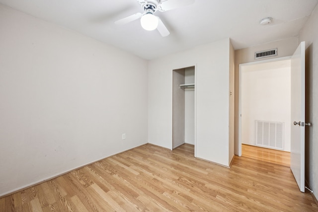 unfurnished bedroom with a closet, light wood finished floors, and visible vents