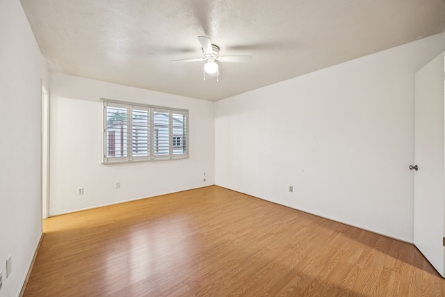 empty room with a ceiling fan and wood finished floors