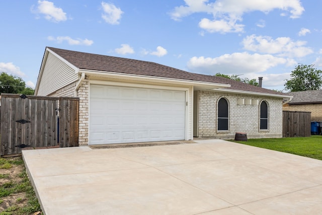 ranch-style home featuring brick siding, a gate, a garage, and concrete driveway