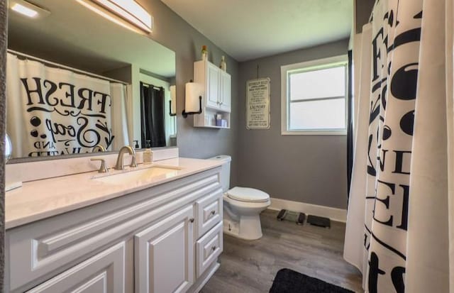 bathroom with vanity, toilet, baseboards, wood finished floors, and a shower with curtain