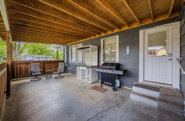 view of patio with fence, entry steps, and a grill