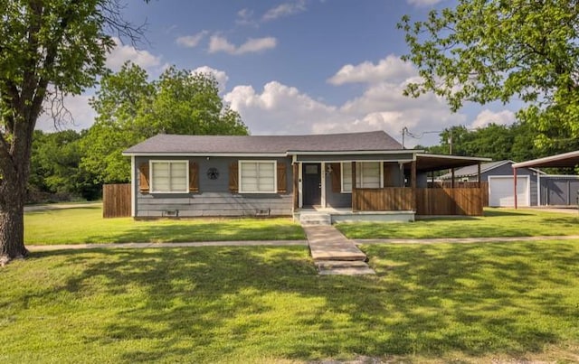 ranch-style house featuring a carport, an outbuilding, a porch, and a front yard