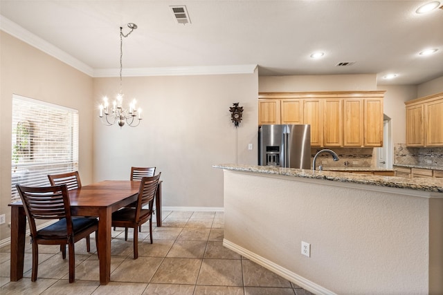 dining room with visible vents, baseboards, crown molding, and a notable chandelier