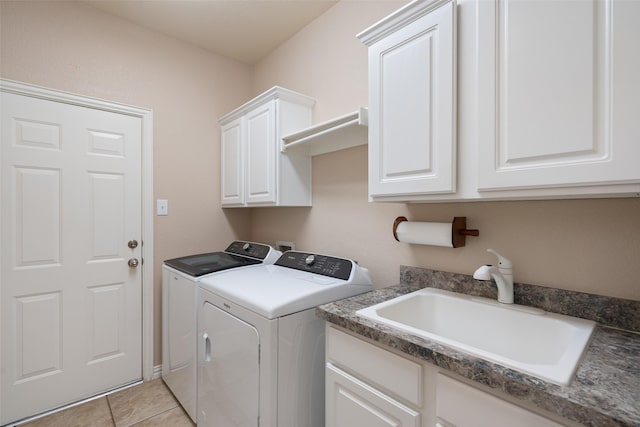 clothes washing area with a sink, cabinet space, light tile patterned floors, and washer and dryer