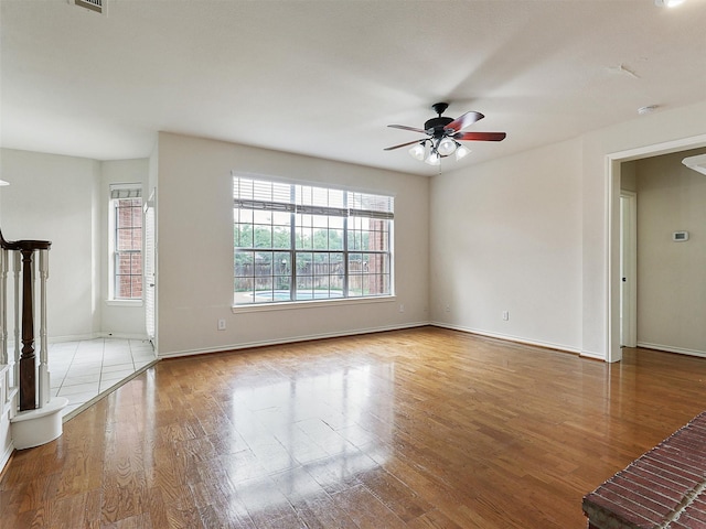 unfurnished living room featuring baseboards, ceiling fan, and wood finished floors
