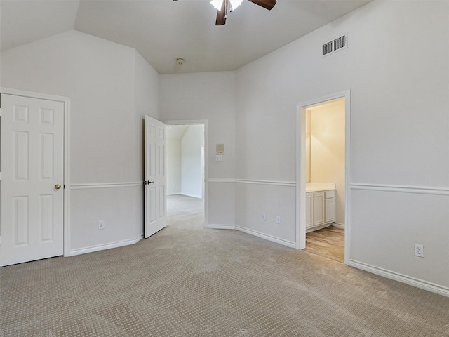 unfurnished bedroom with visible vents, vaulted ceiling, baseboards, carpet, and ensuite bath