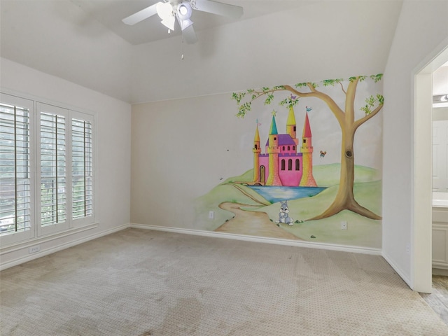 empty room featuring ceiling fan, vaulted ceiling, baseboards, and carpet