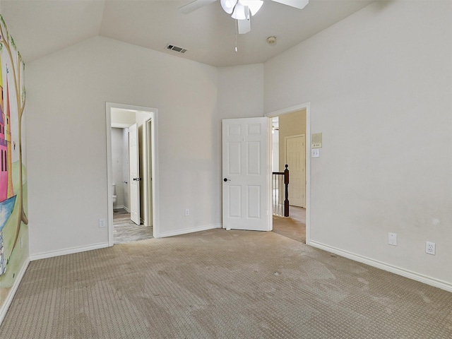 unfurnished bedroom featuring carpet flooring, baseboards, visible vents, and vaulted ceiling