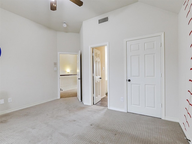 unfurnished bedroom with carpet flooring, baseboards, ensuite bathroom, vaulted ceiling, and visible vents