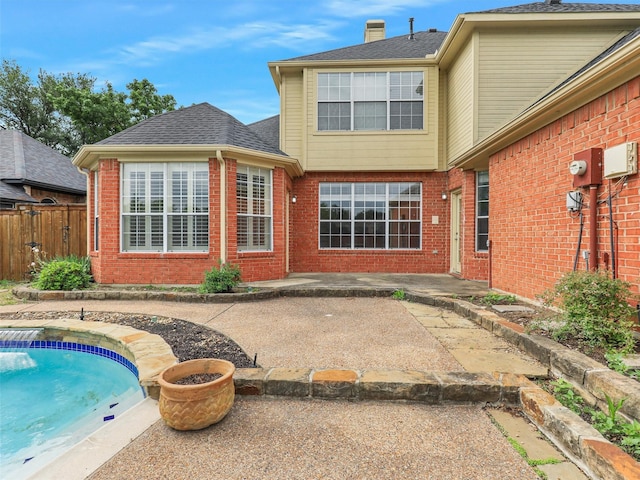 back of property featuring brick siding, fence, a fenced in pool, and a patio
