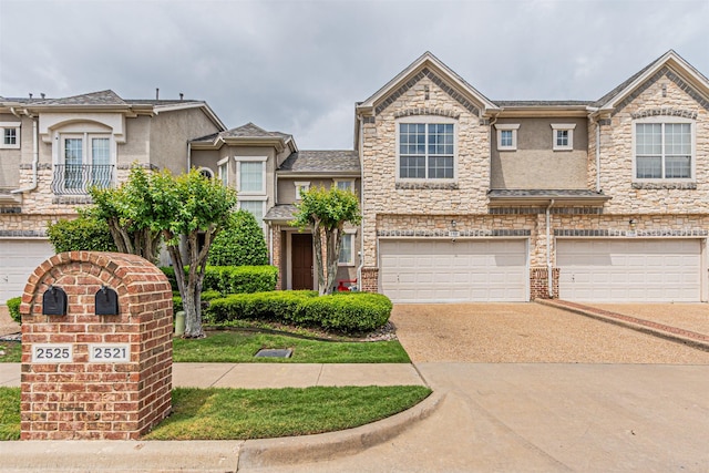 view of property with a garage, stucco siding, driveway, and stone siding