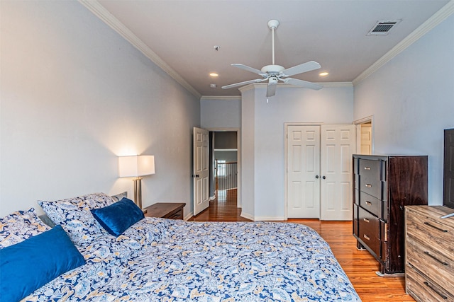 bedroom featuring light wood-type flooring, ornamental molding, visible vents, and recessed lighting