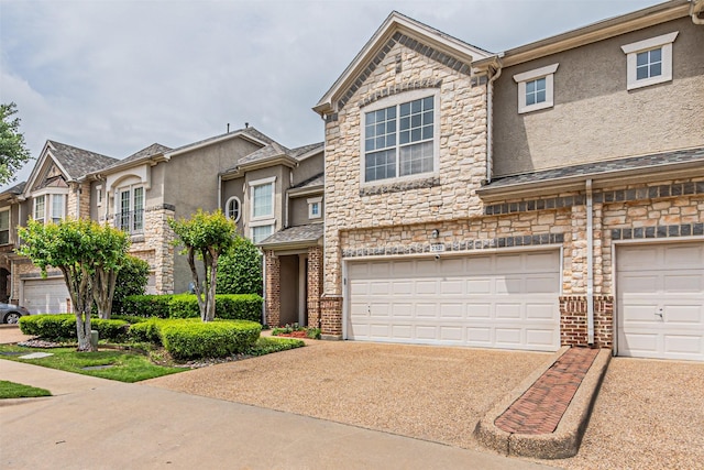 view of property with a garage, stucco siding, stone siding, and concrete driveway