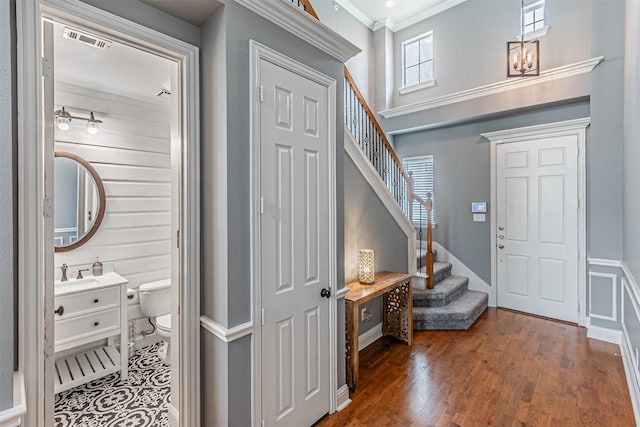 entrance foyer featuring crown molding, stairs, wood finished floors, and visible vents