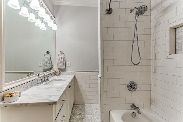 full bath featuring vanity, ornamental molding, wainscoting, tile walls, and shower / washtub combination