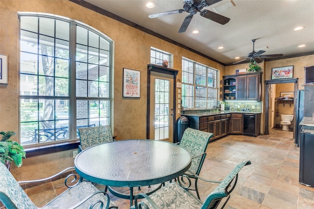 dining space featuring stone finish floor, ceiling fan, a textured wall, and recessed lighting
