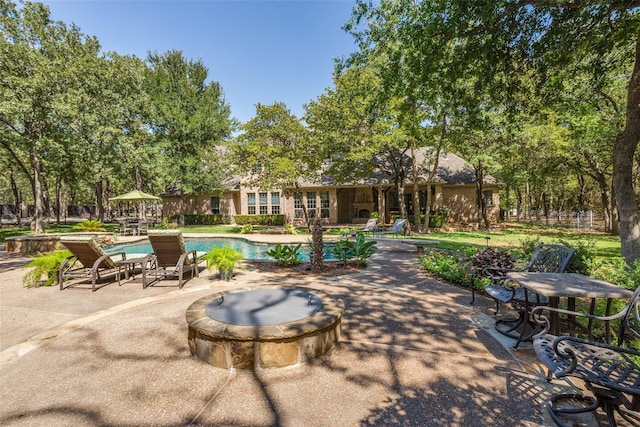 outdoor pool with a patio and an outdoor fire pit