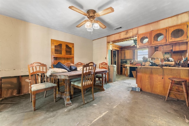 dining space with concrete flooring, ceiling fan, and visible vents