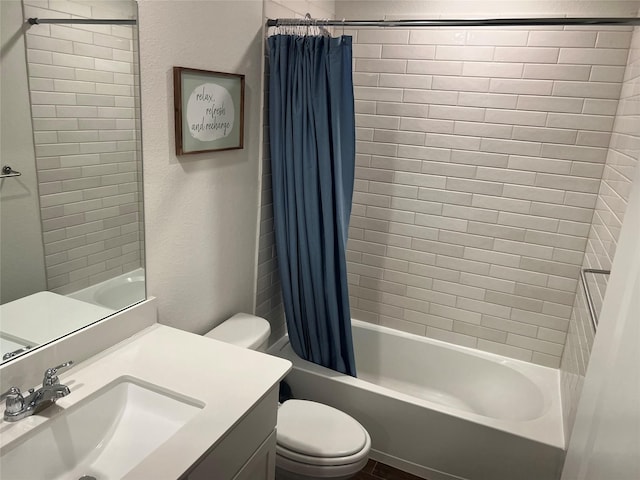bathroom featuring vanity, toilet, a textured wall, and shower / tub combo