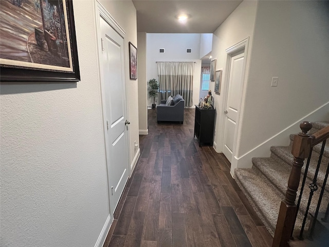 hallway featuring stairway, baseboards, wood finished floors, and visible vents