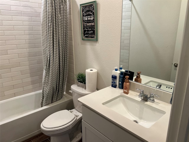 bathroom featuring vanity, a textured wall, shower / bath combo with shower curtain, and toilet
