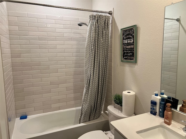 bathroom with toilet, a textured wall, shower / bath combo, and vanity
