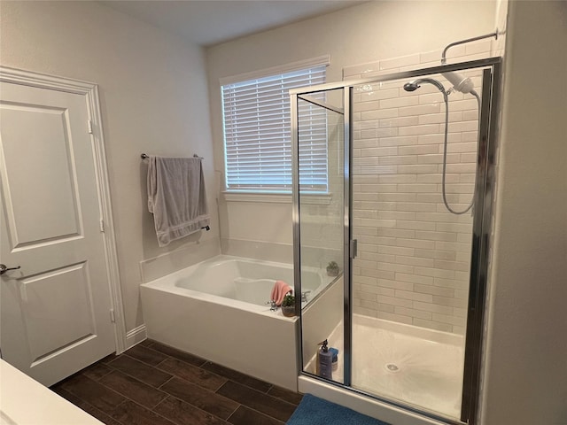full bath with wood tiled floor, a shower stall, and a garden tub