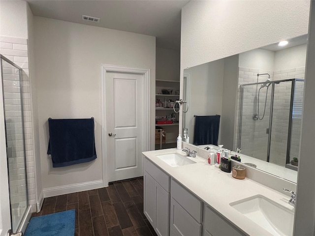 full bath with wood finished floors, a sink, and a stall shower