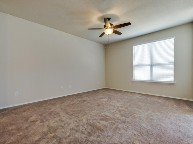 unfurnished room featuring carpet floors, a ceiling fan, and baseboards