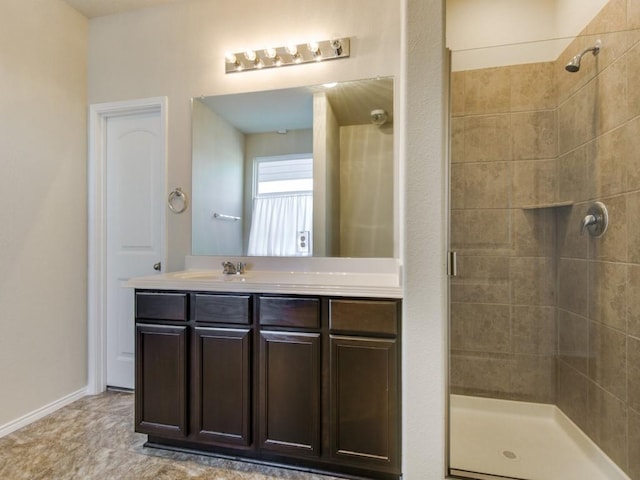 bathroom with vanity, baseboards, and a stall shower
