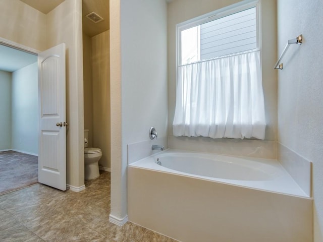 bathroom with visible vents, a bath, and toilet