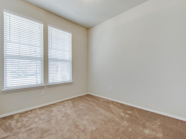 spare room featuring baseboards and carpet