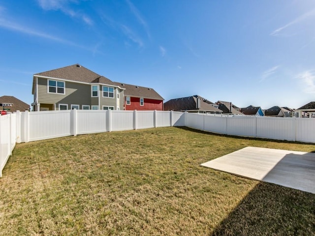 view of yard with a patio, a fenced backyard, and a residential view